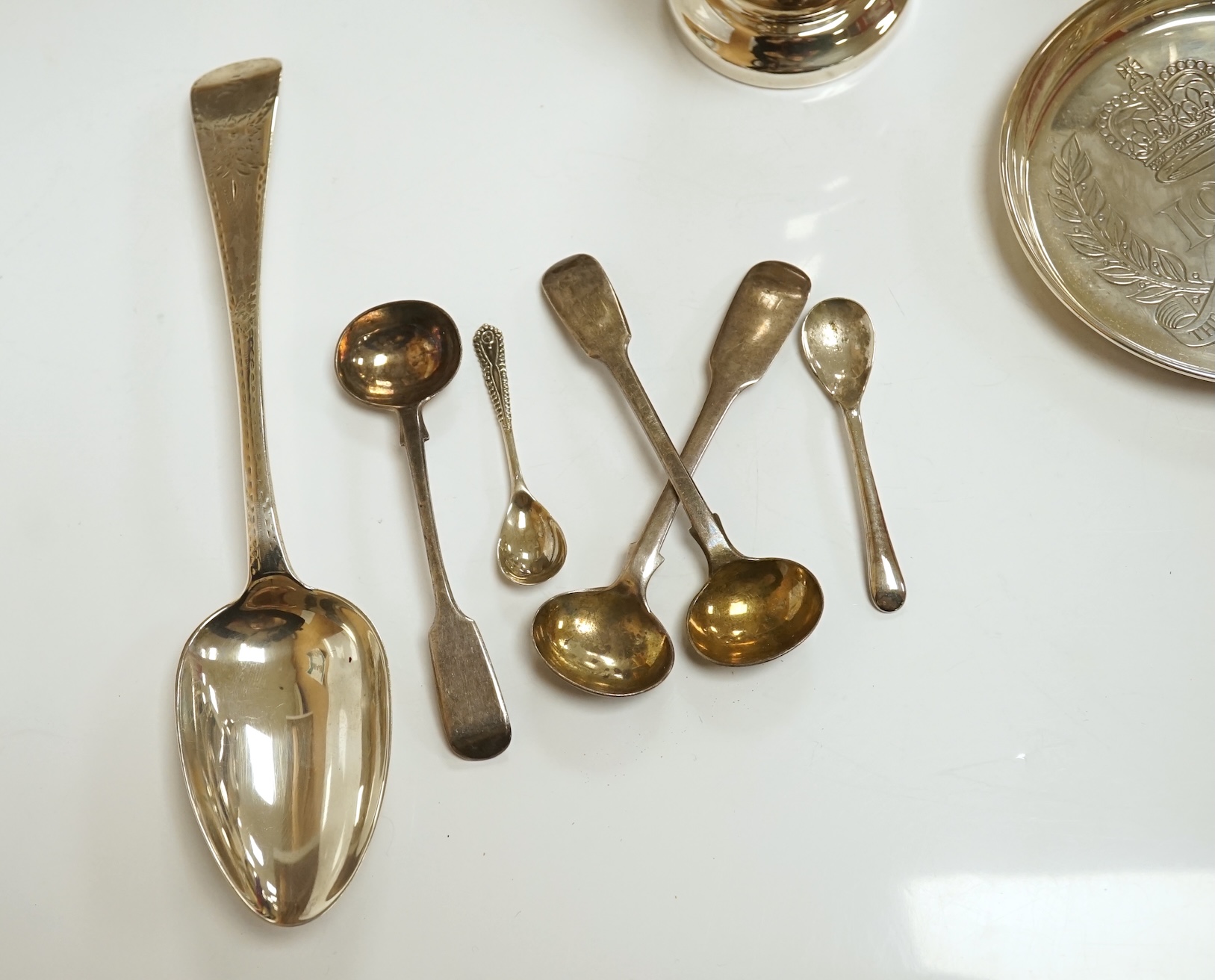 Assorted small silver including a 1970's cream jug, 15.6cm, a sauceboat, a sugar caster, three condiments, a small commemorative dish, a George III table spoon, hand mirror and four condiment spoons, 18.6oz. Condition -